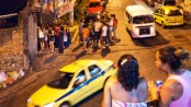 Favela residents in Vidigal watch at the entrance of the Lamparina party