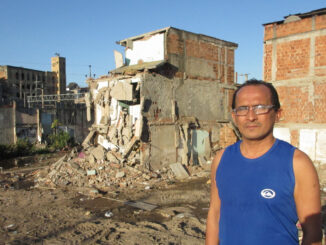 Lélio Fernandes stands in front of his half-demolished house
