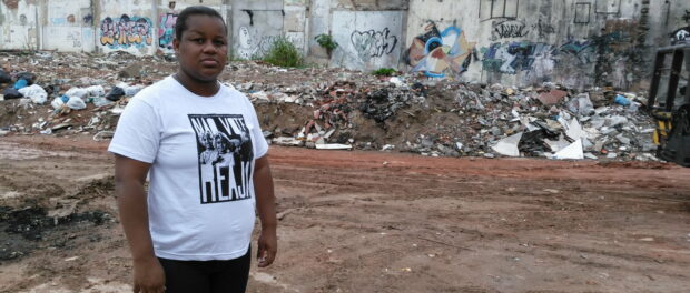 Resident Camila Santos stands in front of the remains of Favela da Skol.