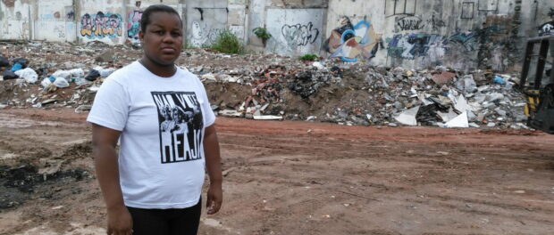 Resident Camila Santos stands in front of the remains of Favela da Skol.