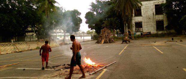 Tribal members engage in traditional rituals during the day, with the Maracanã stadium and old Indigenous Museum in the background