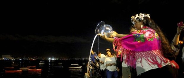 Attendees watch as the water they brought with them from home is poured into the Guanabara Bay. Photo by Domingos Peixoto from Agência O Globo