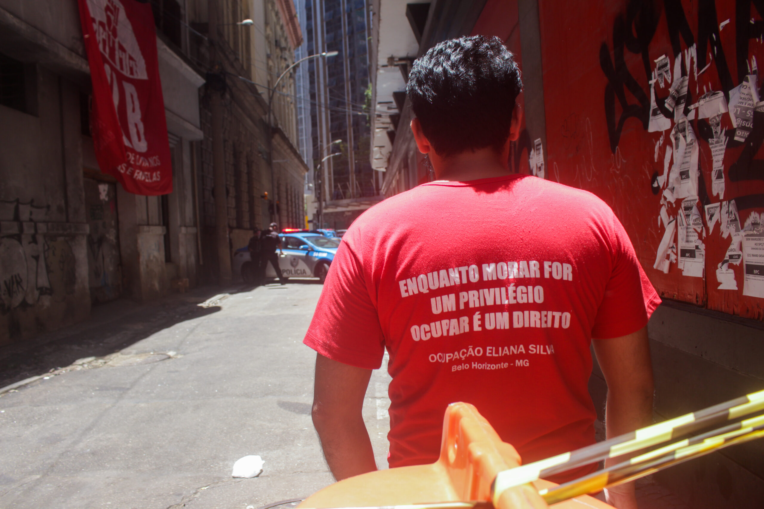 MLB activist wears a t-shirt saying "As long as housing is a privilege, occupying is a right" in front of the Luiz Gama Occupation. Photo: Vinícius Ribeiro