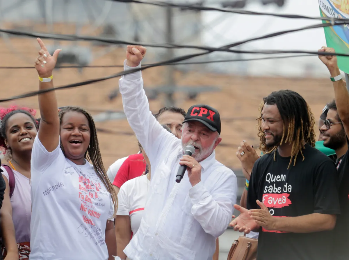 Lula wears a baseball cap with the acronym CPX, which stands for "favela complex." From left to right: State Deputy Dani Monteiro (PSOL-RJ), Camila Moradia, leader from the housing movement from the Skol favela in Complexo do Alemão, Lula, and Rene Silva, activist and founder of community newspaper Voz das Comunidades. Photo: Domingos Peixoto/Agência O Globo