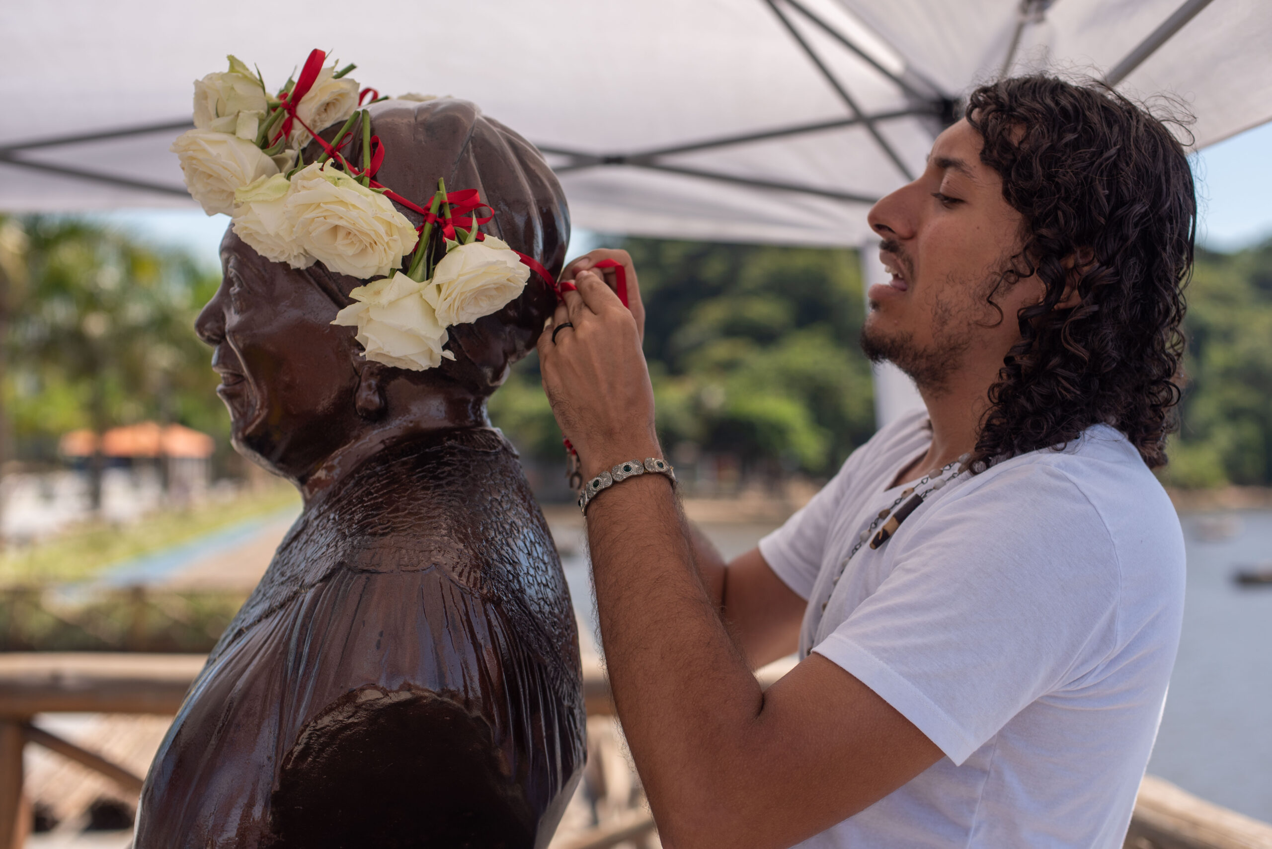 Marcos Cesar, one of the event organizers, crowning the bust of Maria Conga in a bid to repair the act of vandalism toward the bust several days earlier. Photo: Bárbara Dias