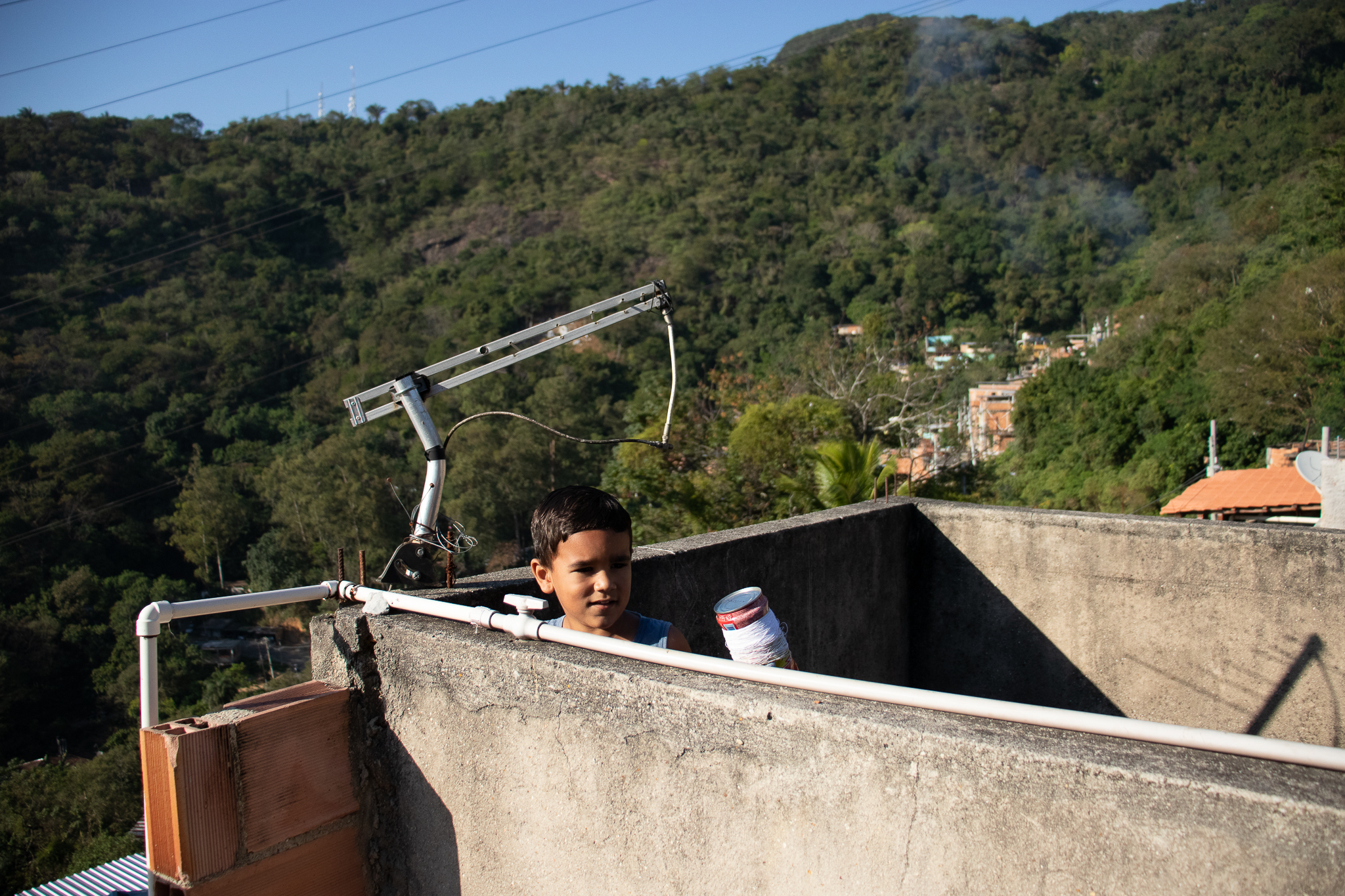 Child watching the Morro do Turano Kite Festival from a roof terrace. Photo: João Fernando
