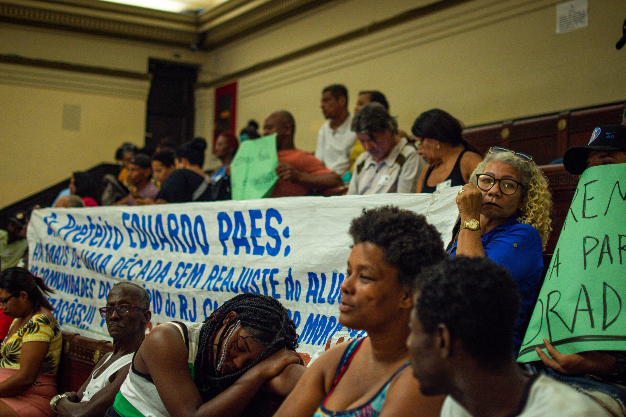 Banner reads “Mayor Eduardo Paes, we have not had an adjustment to social rent for over a decade…”