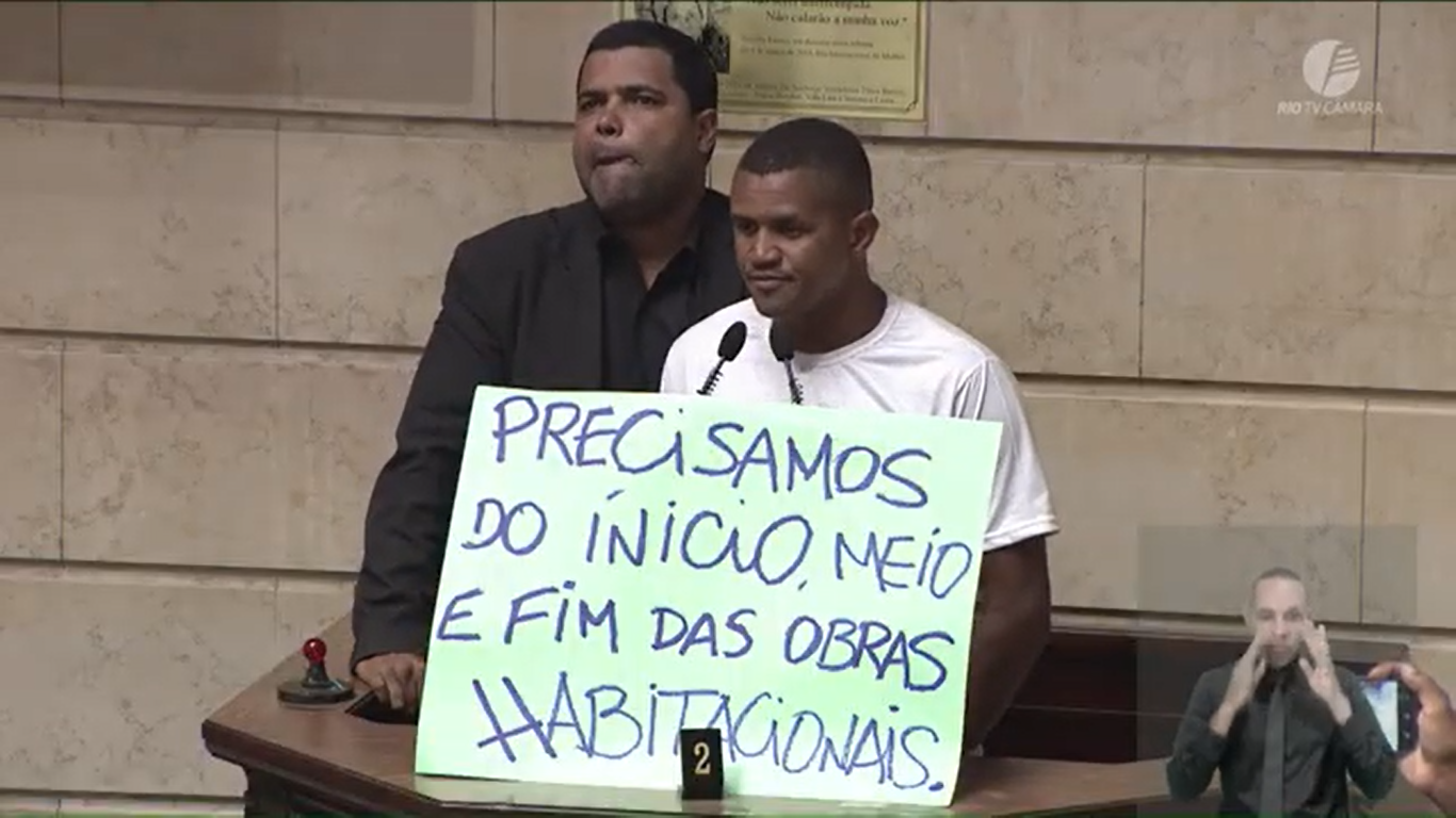 Paulinho Soró from the Jambalaia Occupation in West Zone with a sign saying ‘We need the start, middle, and end of housing works.’ 