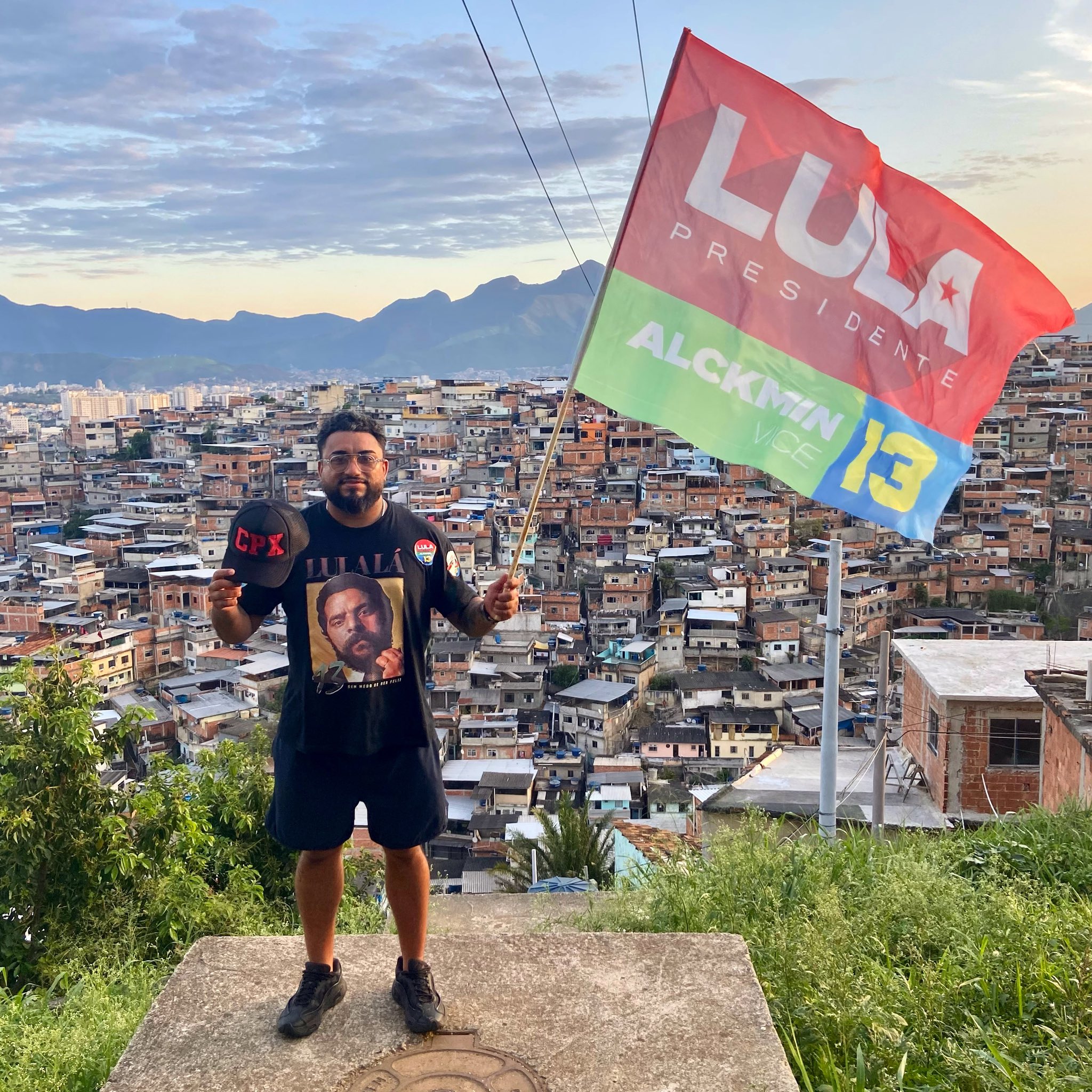 Raull Santiago in Complexo do Alemão with a flag to show support to President Lula following the criminalization of the CPX cap. Photo: Reproduction.