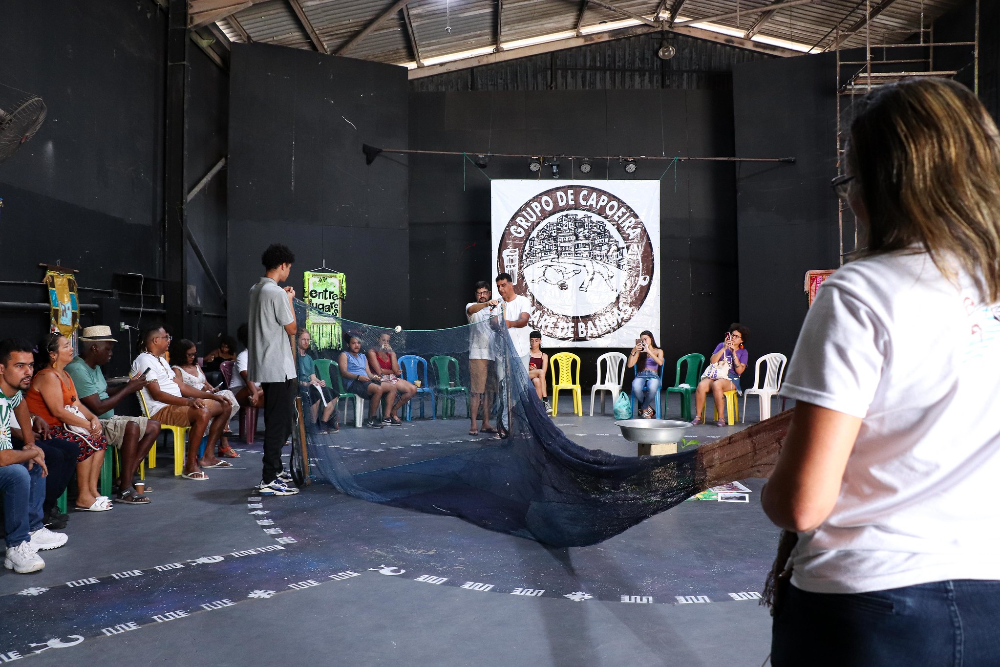 The fishing net displayed in the circle represents important workers in the area, who suffer from difficulties reported by Edilene Nascimento from the Vila do Pinheiro Fishermen’s Association (APEMAR), such as pollution, accumulated garbage, and neglect of Maré's mangroves. Photo: Alexandre Cerqueira 