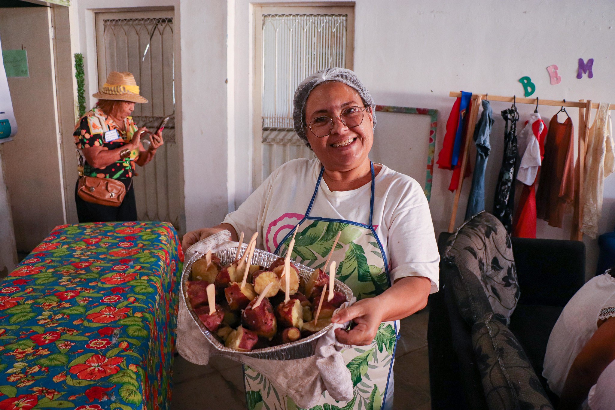 Anna Paula Sales, community organizer in Engenho, Itaguaí, and founder of the Itaguaí Women's Association—Warriors and Social Articulators (A.M.I.G.A.S.) shows off sweet potatoes being served in the Itaguaí Solidarity Kitchen. Photo: Alexandre Cerqueira