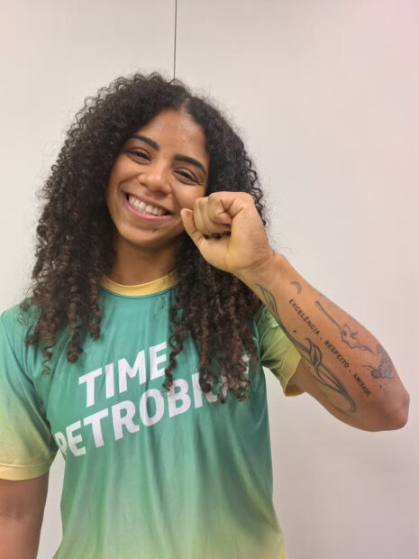 Laura Amaro, weightlifting athlete, born and raised in Cascadura, shows her tattoo that reads 'excellence, respect, friendship.' Photo: Larissa Carvalho/ge.globo