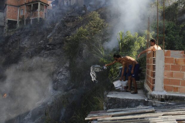 Residents try to put out a fire in Complexo do Alemão. Photo: A Nova Democracia newspaper