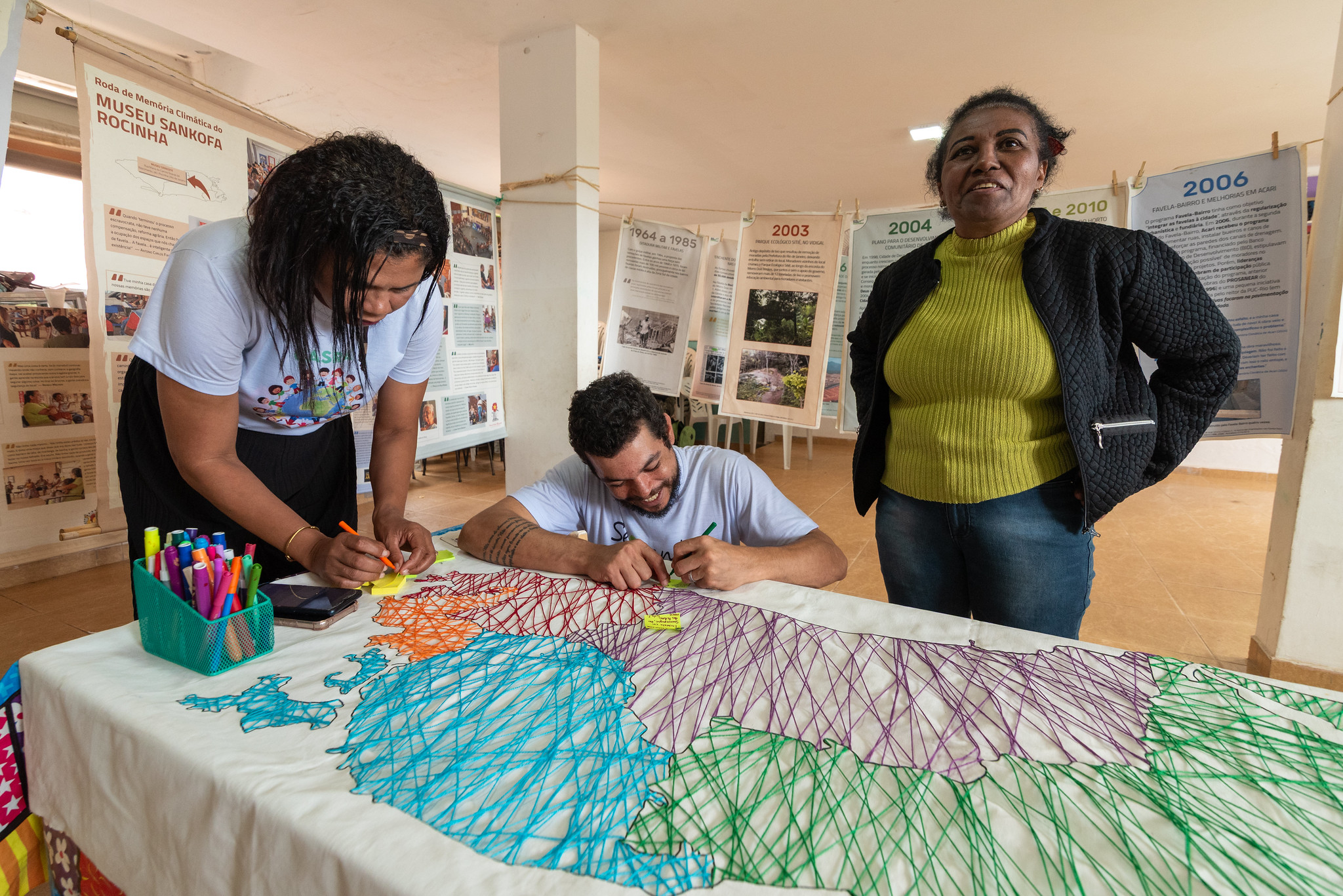 Os moradores interagem com o mapa criado pelo artista Marli Damascena, co -fundador do Museu Maré, na abertura da exposição no Rio Das Pedras Favela. Foto: Bárbara Dias