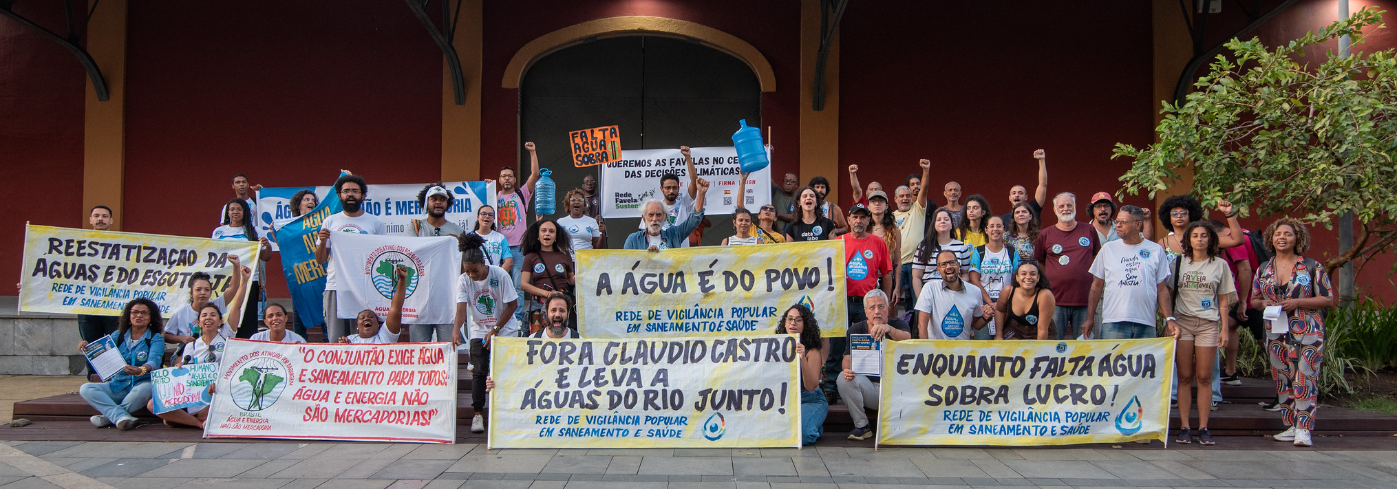 Protesters hold banners during a World Water Day demonstration in front of Águas do Rio, in downtown Rio de Janeiro. Photo: Bárbara Dias Protesters hold banners during a World Water Day demonstration in front of Águas do Rio, in downtown Rio de Janeiro. Photo: Bárbara Dias